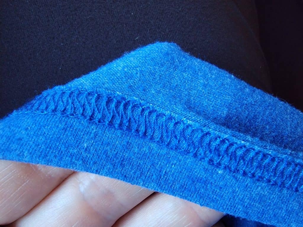 Back of coverstitch on blue fabric.