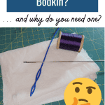 What is a Bodkin? ... and why do you need one? Picture of a bodkin and loop pouller on white fabric on a cutting mat with a spool of purple thread follows.